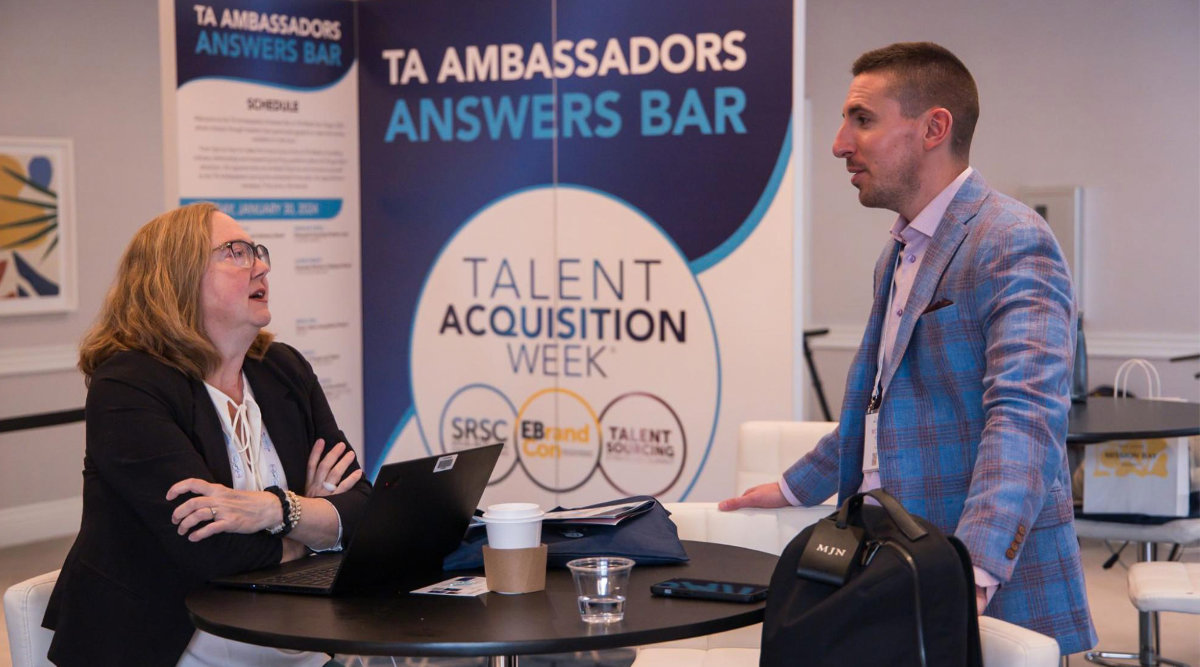 Two people talking at a conference